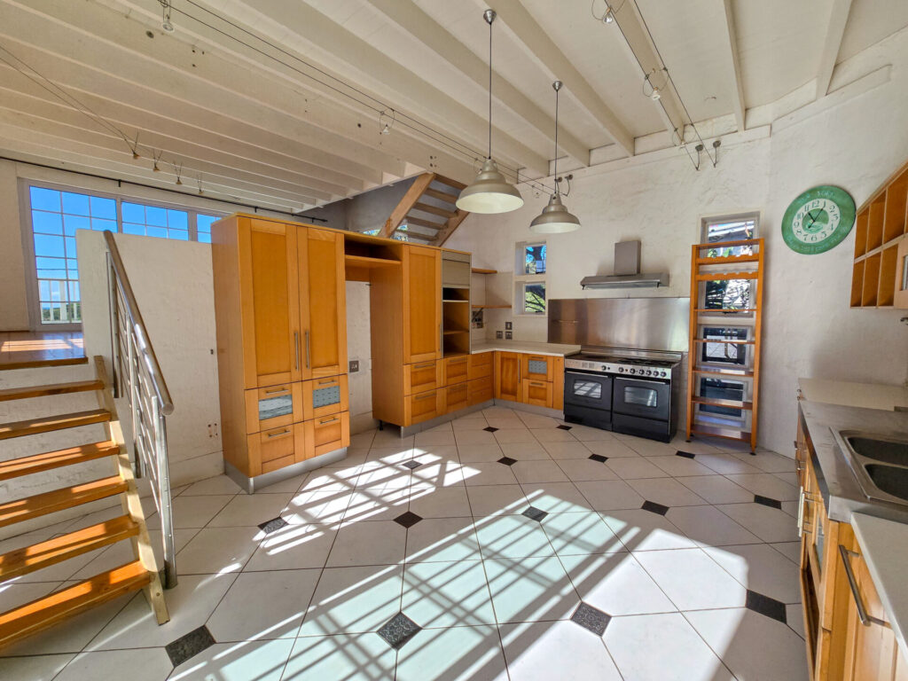 Bright kitchen with timber cupboards and stairs to an upper level
