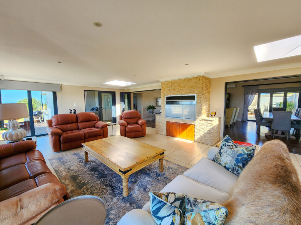Open-plan living room with large windows and leather seating