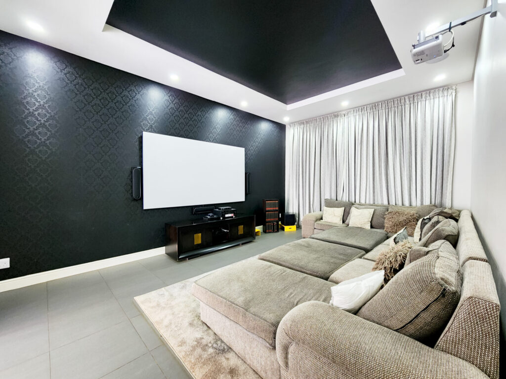 Living room with a corner sofa and dark television feature wall