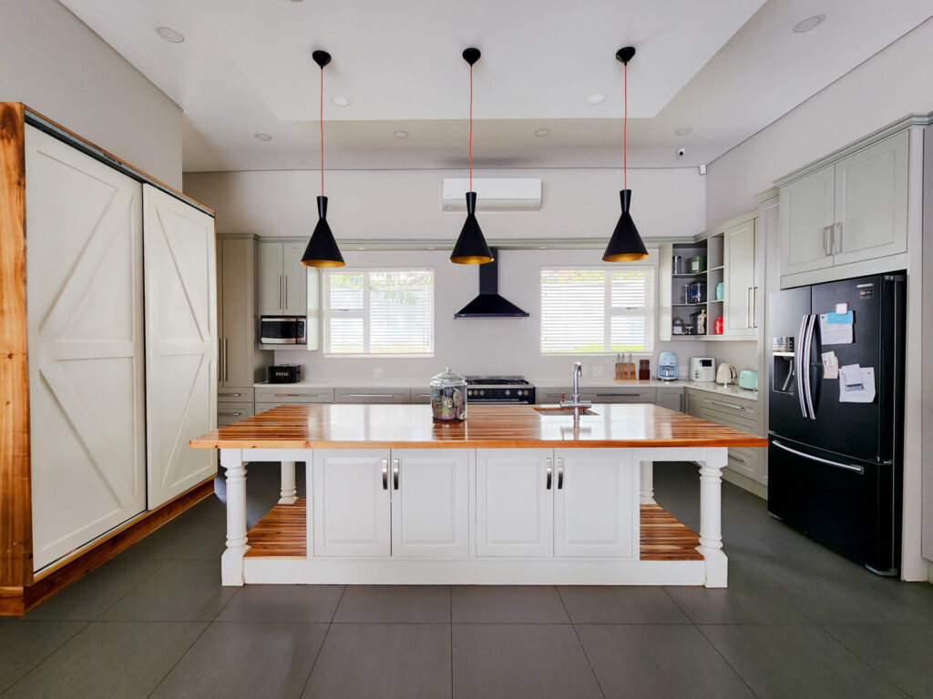 White kitchen with a central island and three black pendant lights