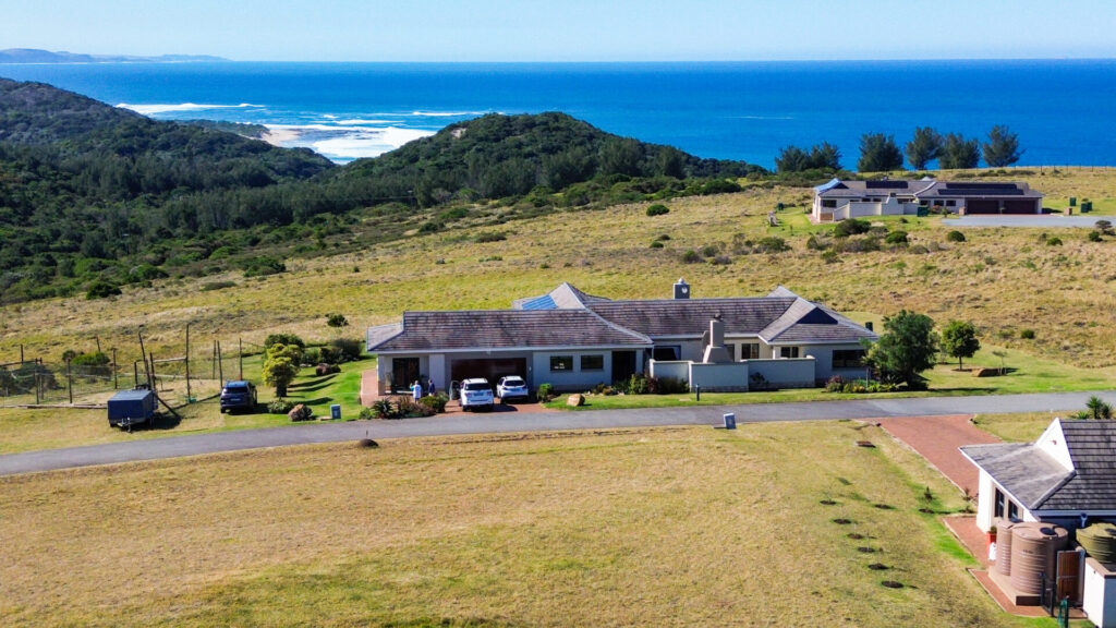 Aerial view of a home in an open coastal landscape with sea views