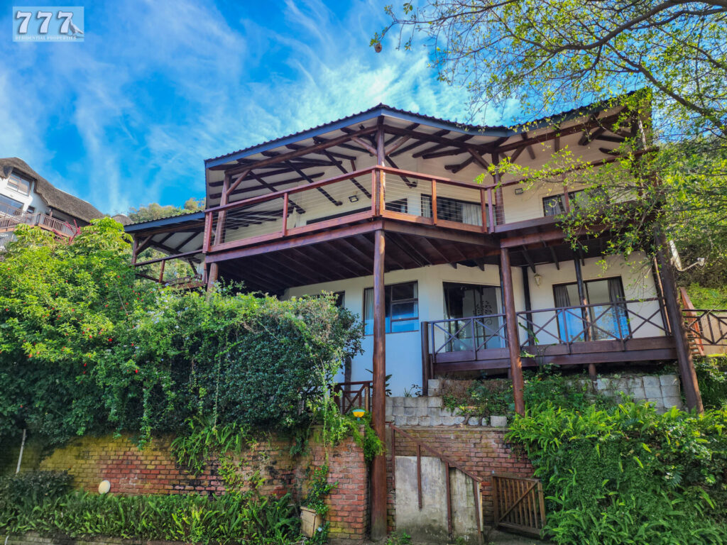 Home with a covered timber balcony surrounded by trees