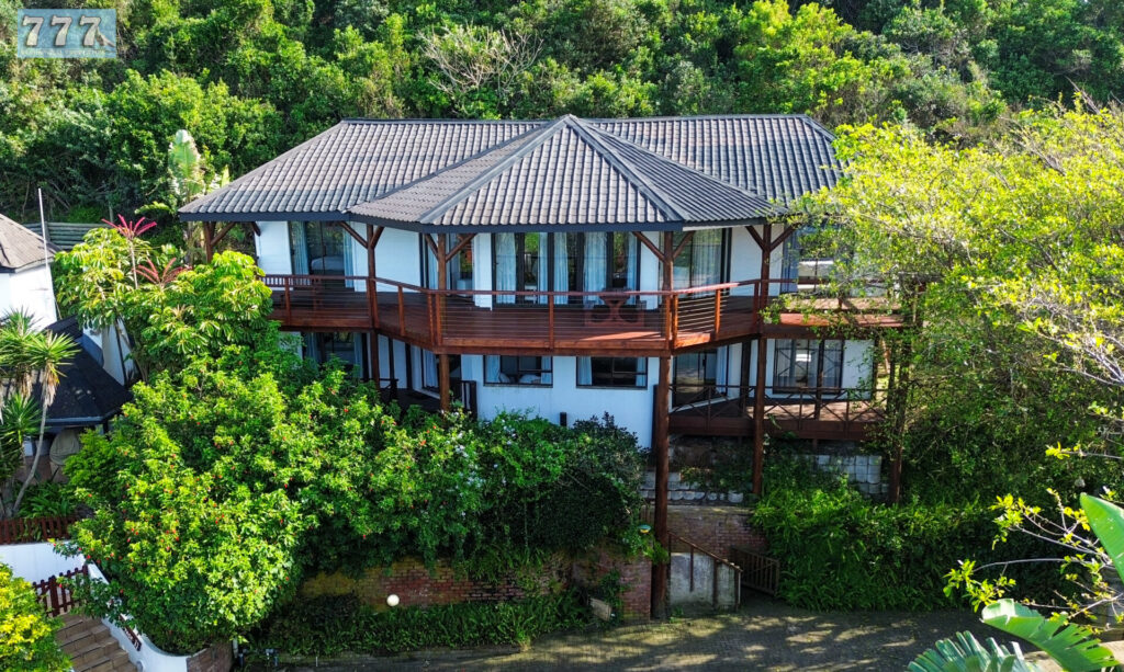 Two-storey home with wraparound balconies overlooking dense greenery