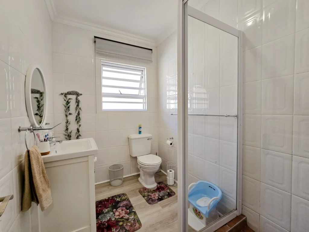 Bathroom with glass shower, vanity and window