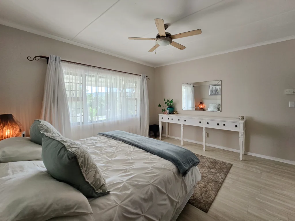 Bedroom with garden-facing windows and a dressing table