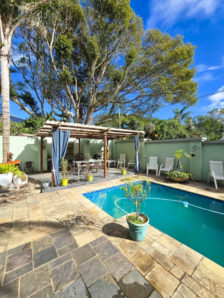 Swimming pool, stone patio and shaded outdoor seating