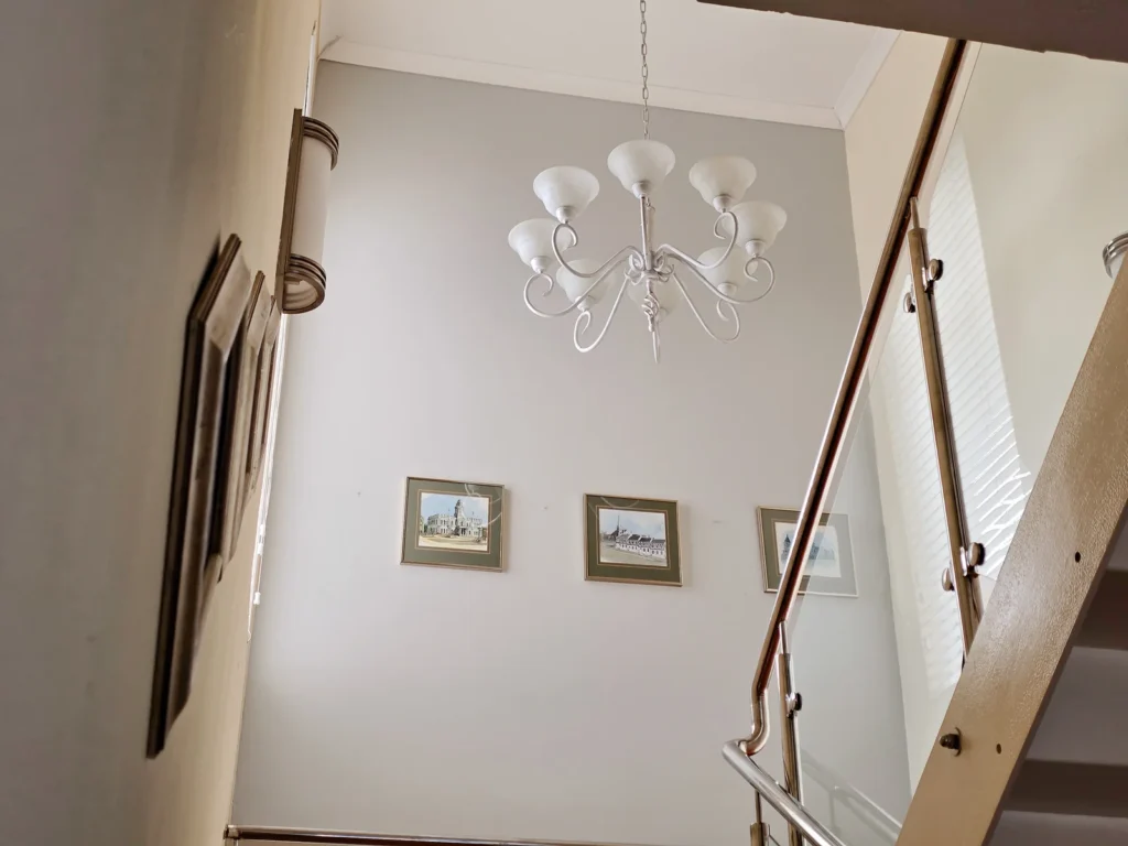 Stairwell with framed pictures and a hanging light