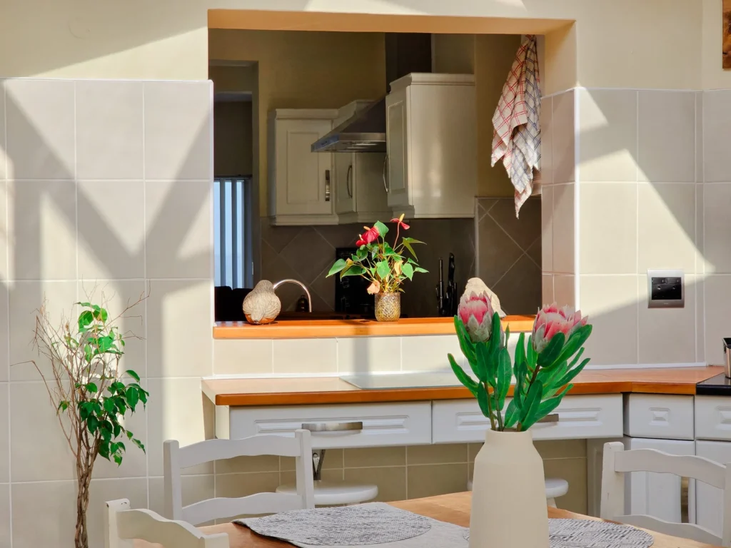Dining table with tulips beside a kitchen breakfast counter